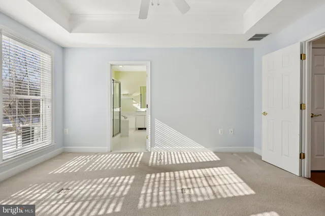 a view of a bedroom with wooden floor and a bathroom