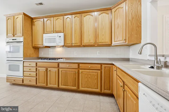 a kitchen with granite countertop a sink stainless steel appliances and cabinets