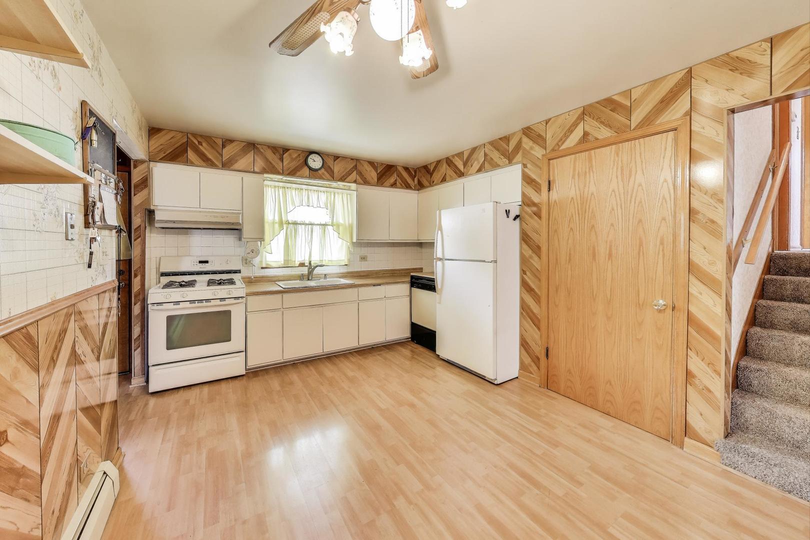 4121 Maple Avenue Lyons, IL 60534 - Photo 8 of 32 a kitchen with stainless steel appliances a refrigerator a sink dishwasher a stove and white cabinets with wooden floor