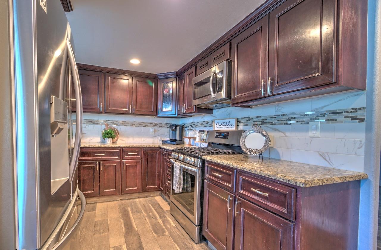 a kitchen with stainless steel appliances granite countertop a sink stove and refrigerator