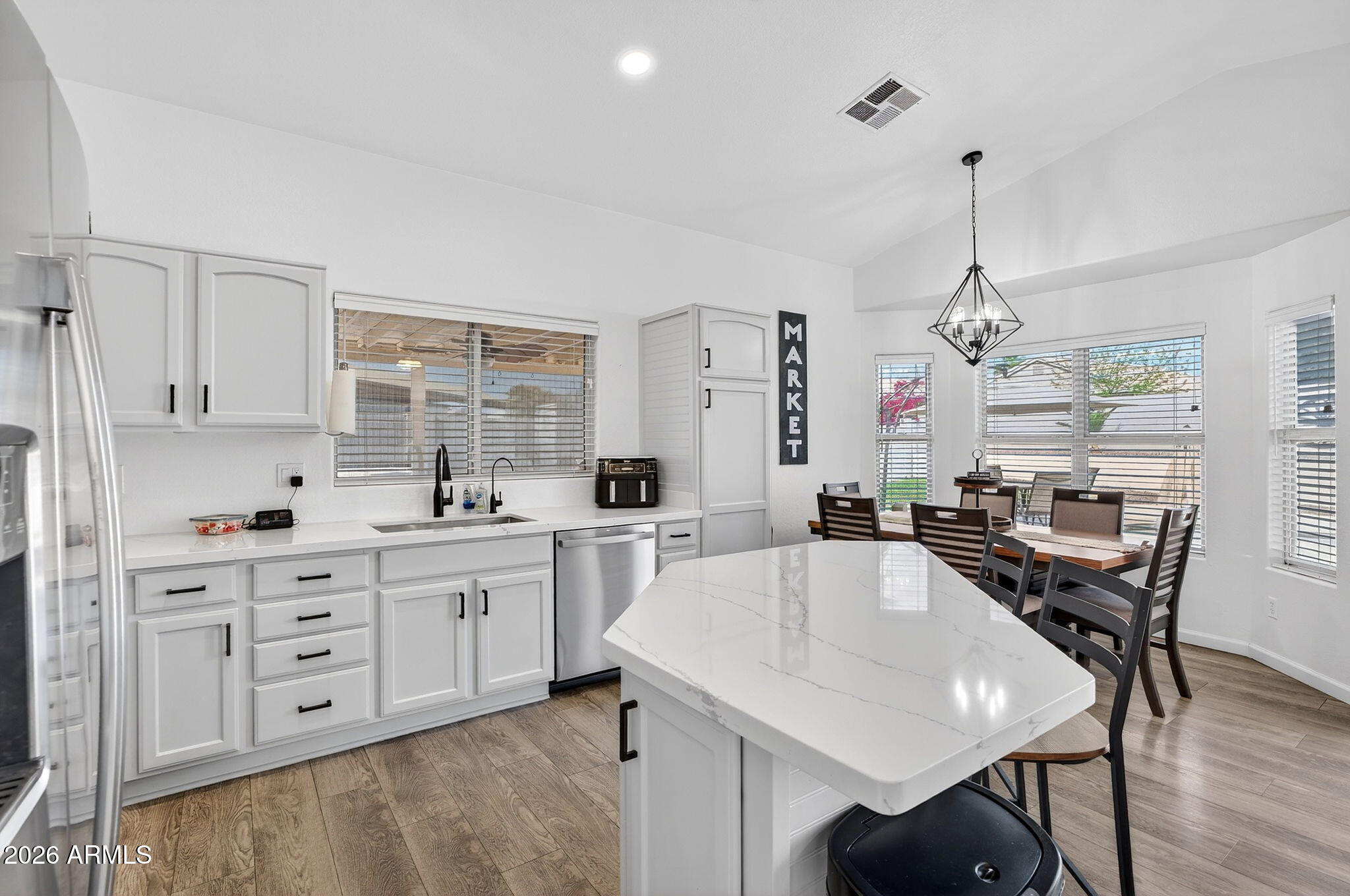 4630 East Dry Creek Road Phoenix, AZ 85044 - Photo 13 of 60 a large white kitchen with granite countertop a stove a sink a dining table and chairs