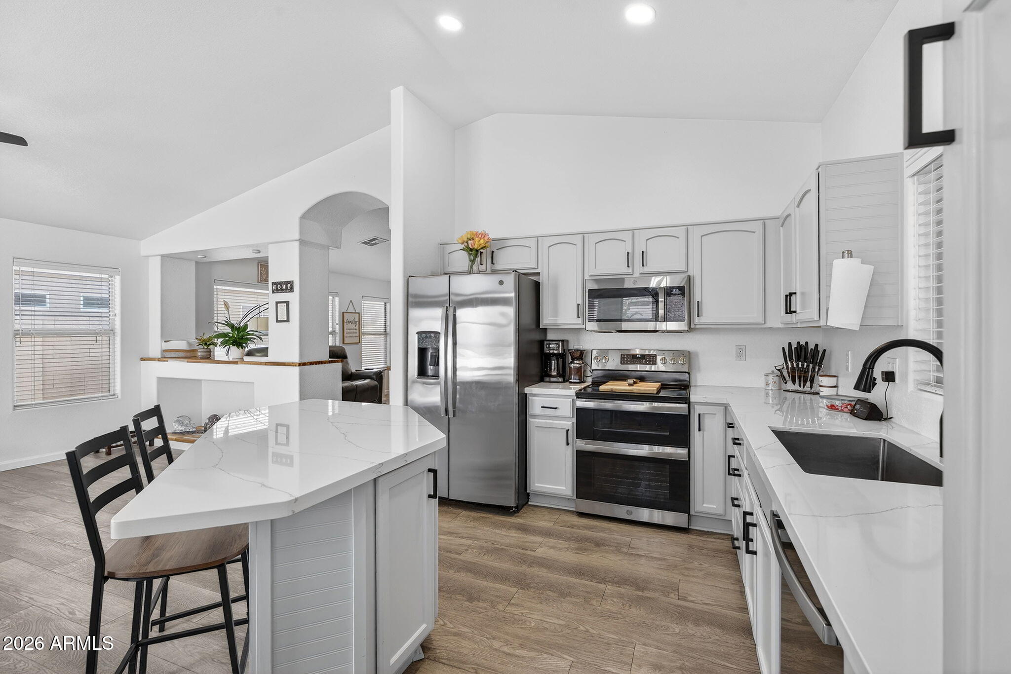 4630 East Dry Creek Road Phoenix, AZ 85044 - Photo 10 of 60 a kitchen with stainless steel appliances a stove a sink dishwasher a refrigerator and a stove with wooden floors