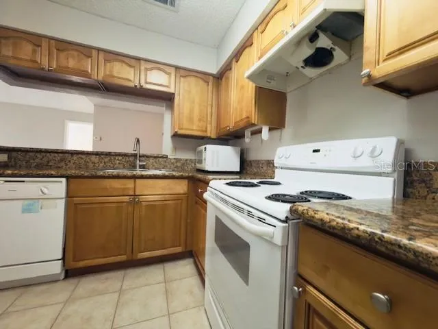a kitchen with granite countertop cabinets stainless steel appliances and a sink