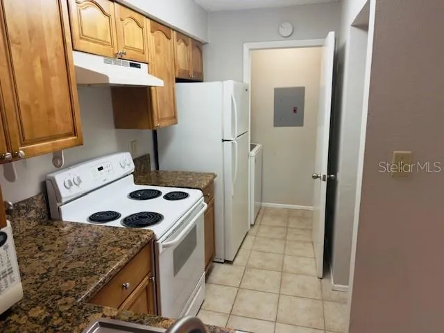 a kitchen with a refrigerator sink and cabinets