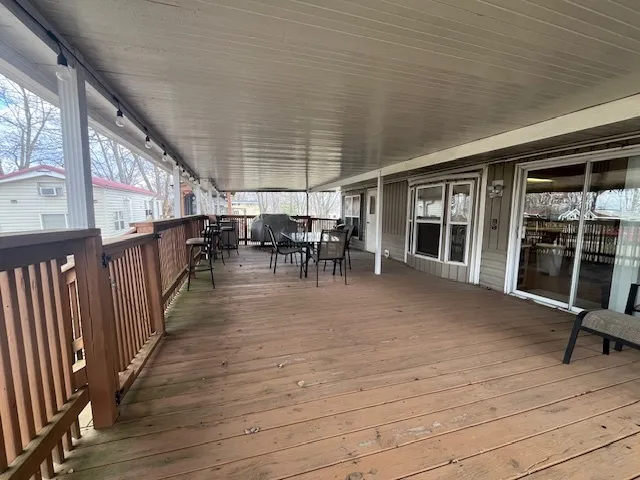 a view of a chairs and table on the wooden roof deck