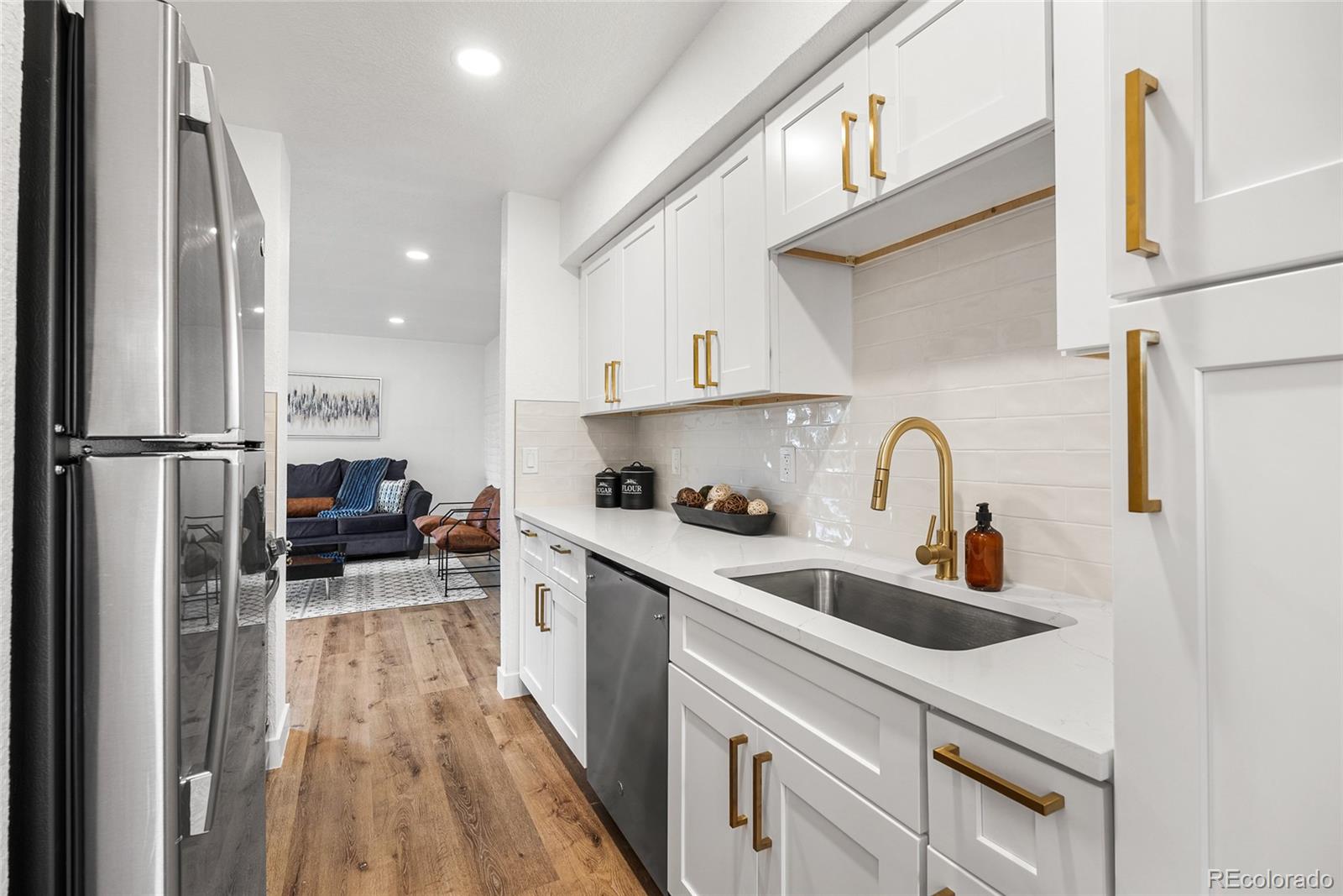 1060 South Parker Road, Unit 35 Denver, CO 80231 - Photo 5 of 25 a kitchen with stainless steel appliances a sink dishwasher a refrigerator and cabinets with wooden floor