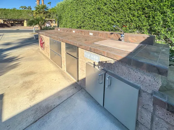 a view of a swimming pool with a yard and palm trees