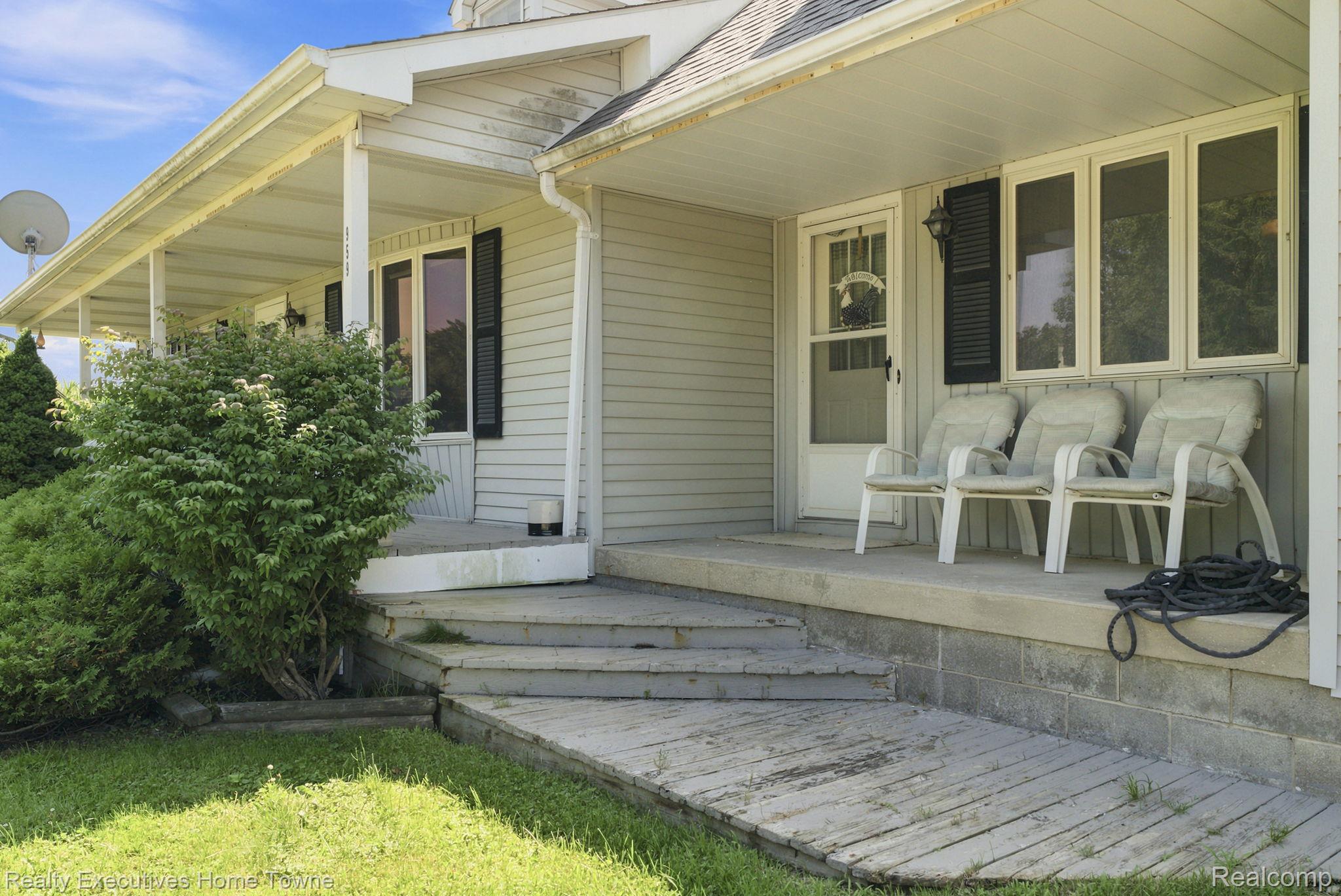 959 Braidwood Road Memphis, MI 48041 - Photo 12 of 58 Front facade featuring a covered porch, vinyl siding, and black louvered shutters
