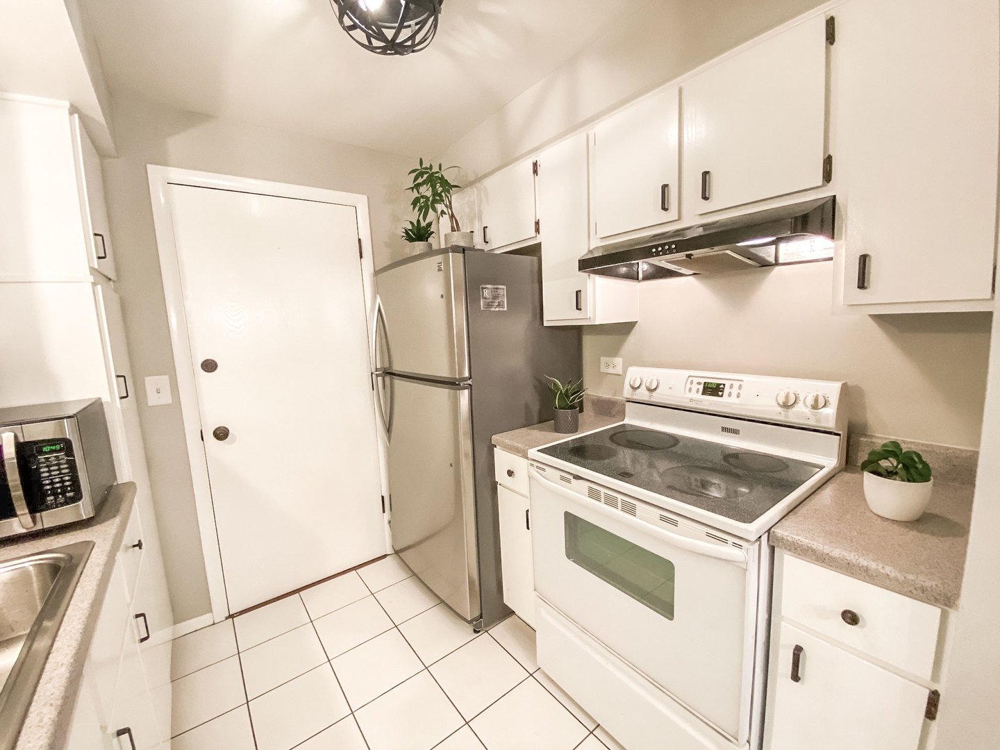 5113 North East River Road, Unit 3C Chicago, IL 60656 - Photo 6 of 11 a kitchen with a stove top oven and refrigerator