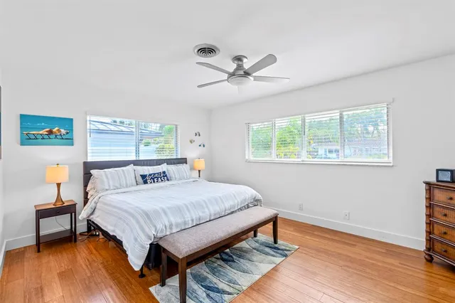 a bedroom with a bed and wooden floor