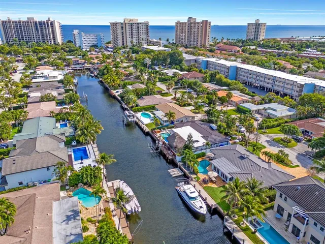 an aerial view of residential houses with outdoor space and lake view