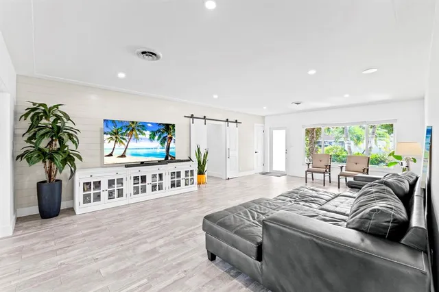 a kitchen with stainless steel appliances kitchen island granite countertop a table chairs and a refrigerator