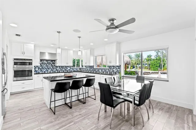 a kitchen with stainless steel appliances a table and chairs