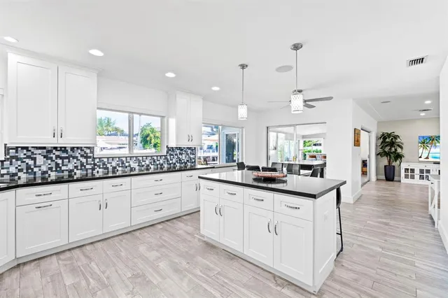 a kitchen with stainless steel appliances kitchen island granite countertop a refrigerator and a sink