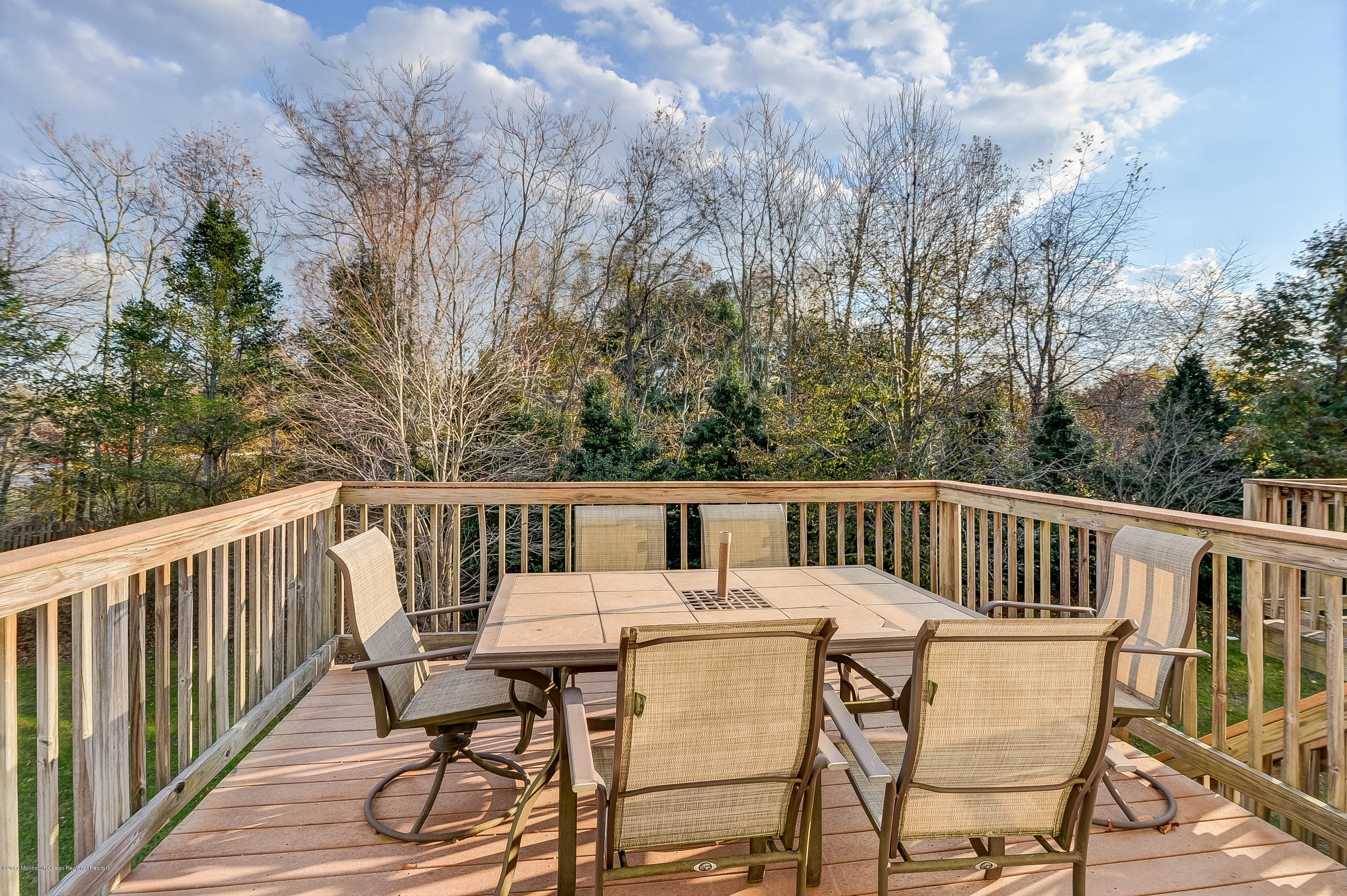 31 Saxton Road, Unit 53 Farmingdale, NJ 07727 - Photo 13 of 25 a view of a chair and table on the deck