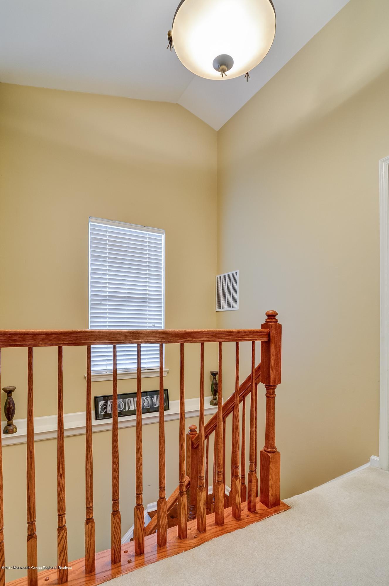 31 Saxton Road, Unit 53 Farmingdale, NJ 07727 - Photo 14 of 25 a view of staircase with railing and a chandelier