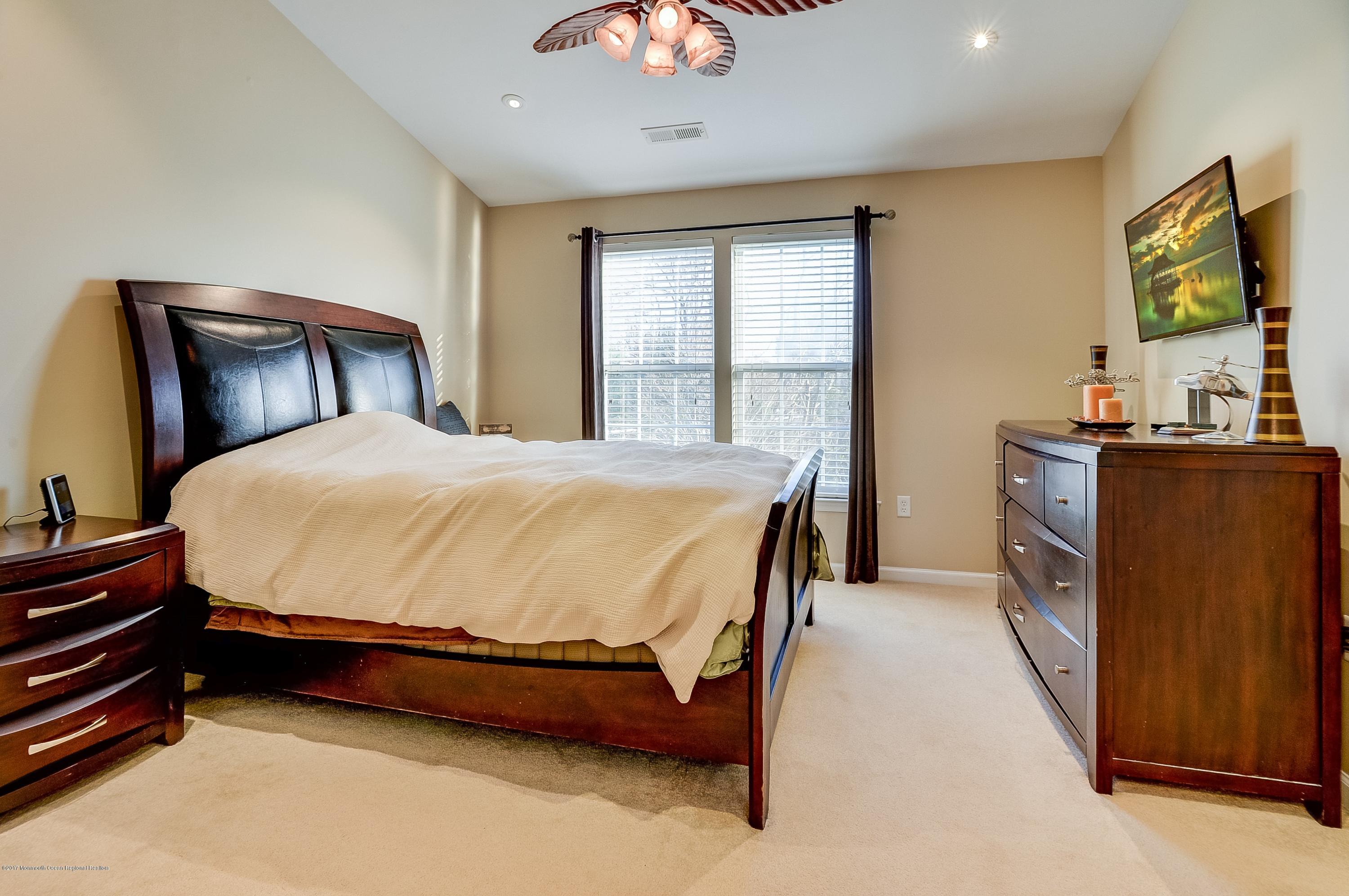 31 Saxton Road, Unit 53 Farmingdale, NJ 07727 - Photo 15 of 25 a bed sitting in a bedroom next to a window