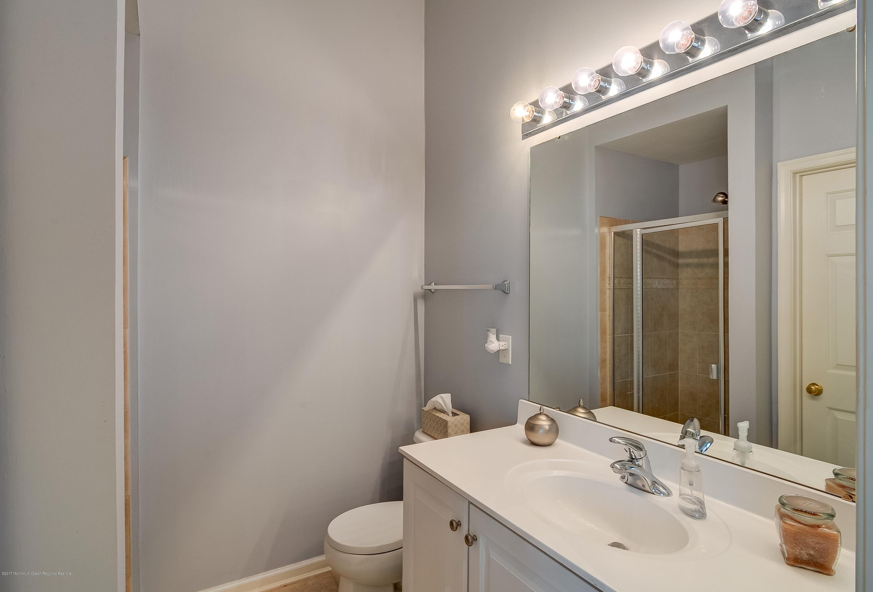 31 Saxton Road, Unit 53 Farmingdale, NJ 07727 - Photo 16 of 25 a bathroom with a toilet a sink and mirror