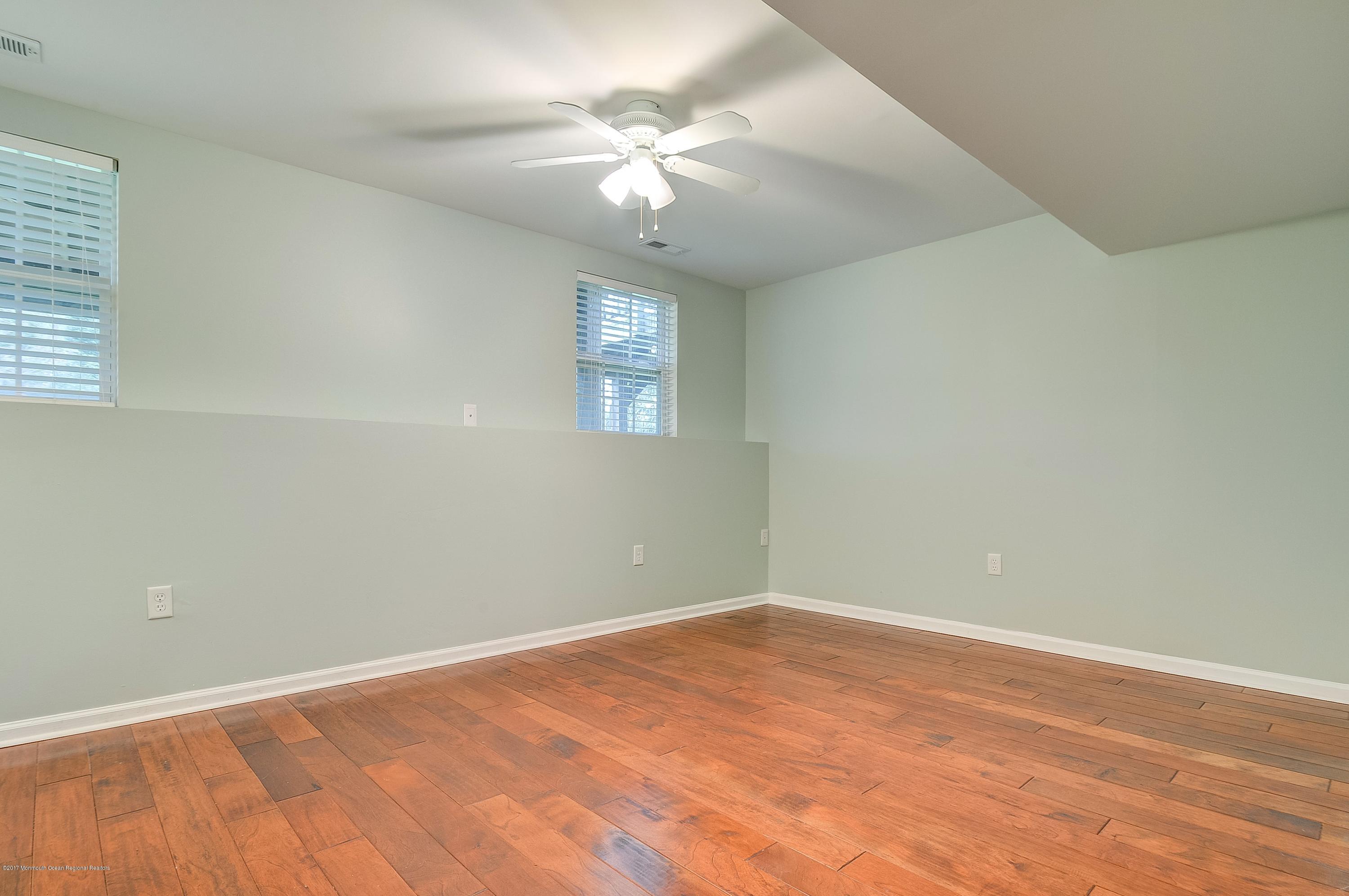 31 Saxton Road, Unit 53 Farmingdale, NJ 07727 - Photo 4 of 25 an empty room with a chandelier fan and windows