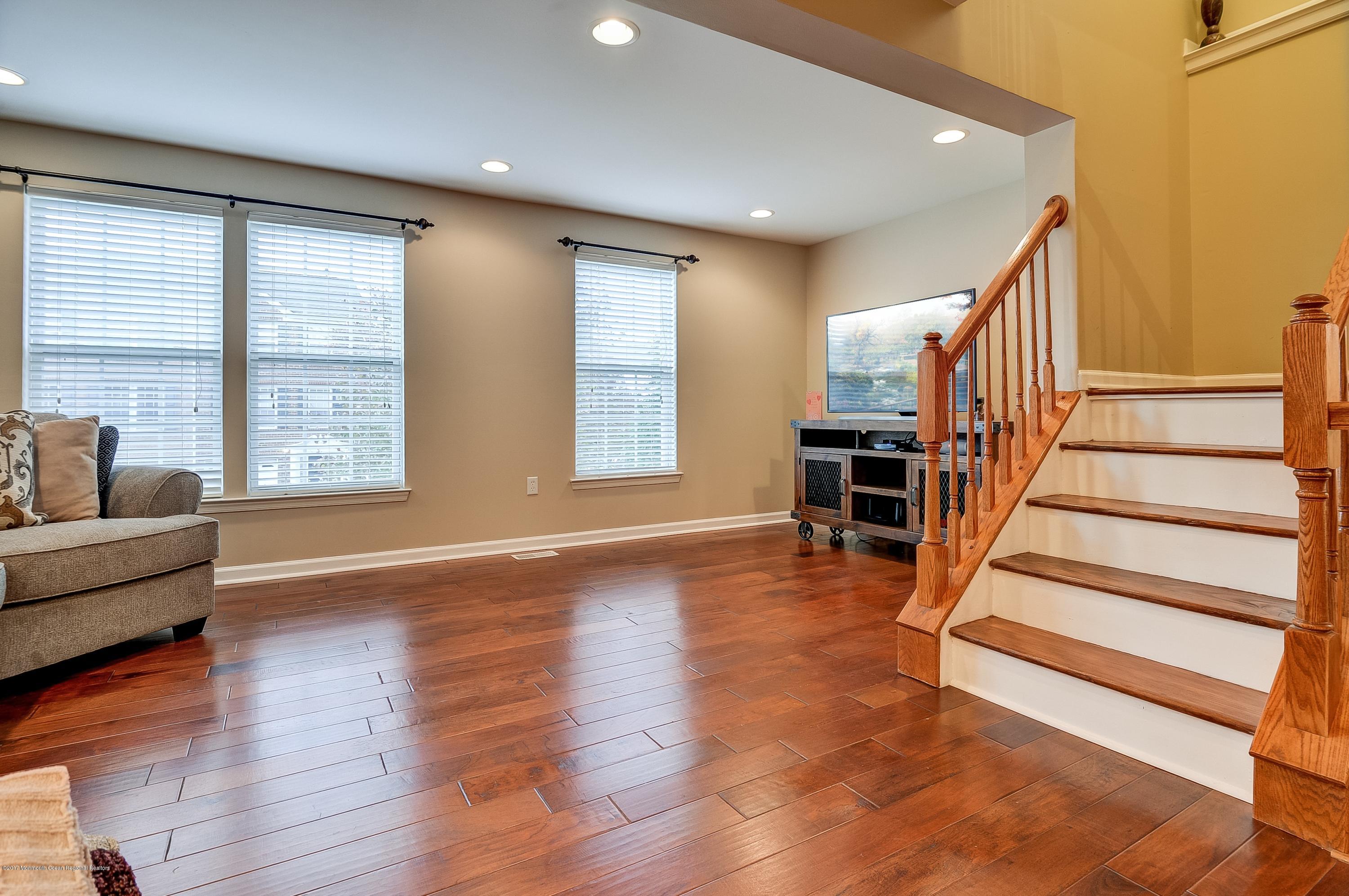 31 Saxton Road, Unit 53 Farmingdale, NJ 07727 - Photo 6 of 25 a view of staircase and living room with wooden floor and windows