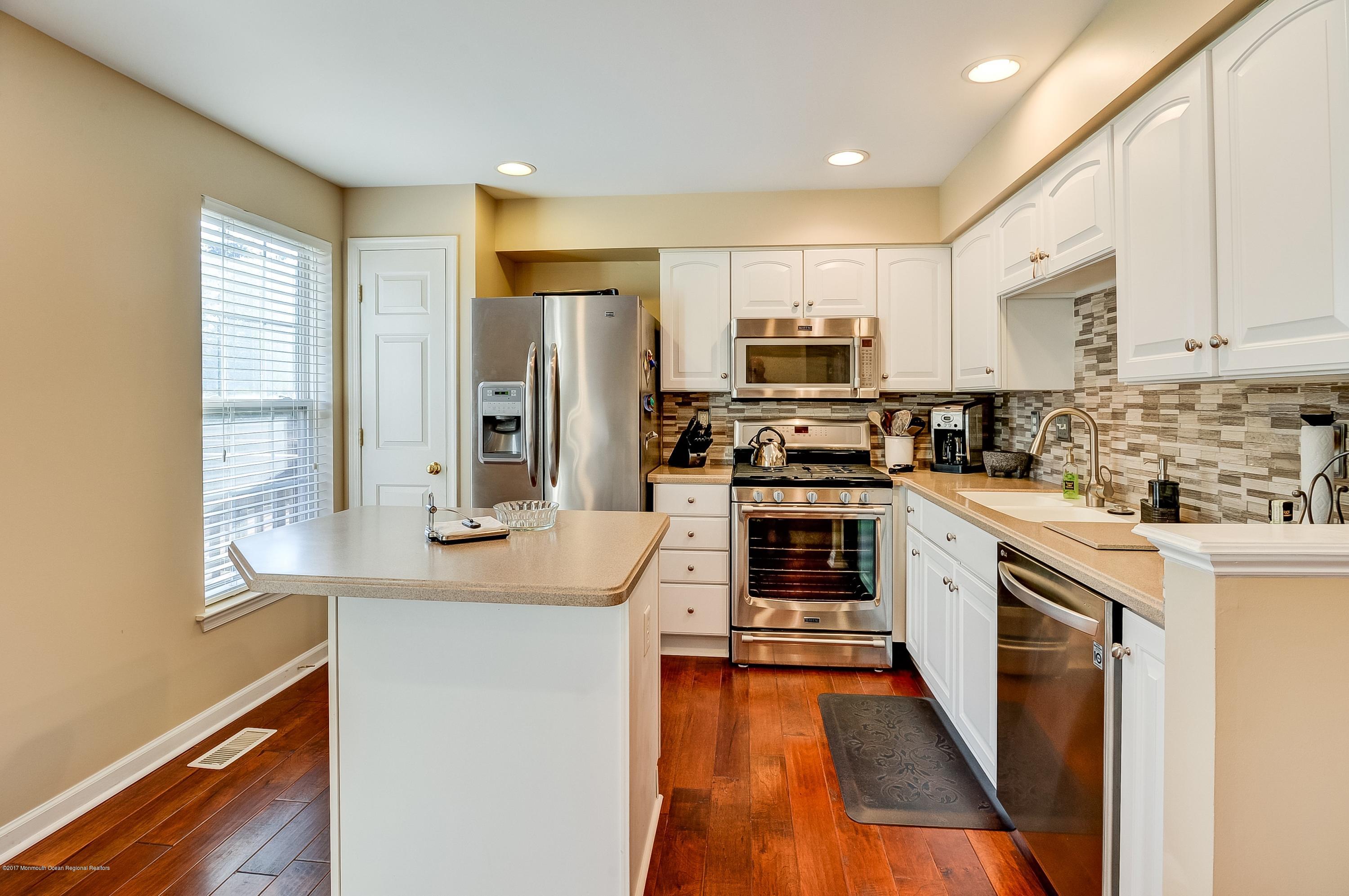 31 Saxton Road, Unit 53 Farmingdale, NJ 07727 - Photo 9 of 25 a kitchen with stainless steel appliances a stove a sink and a refrigerator