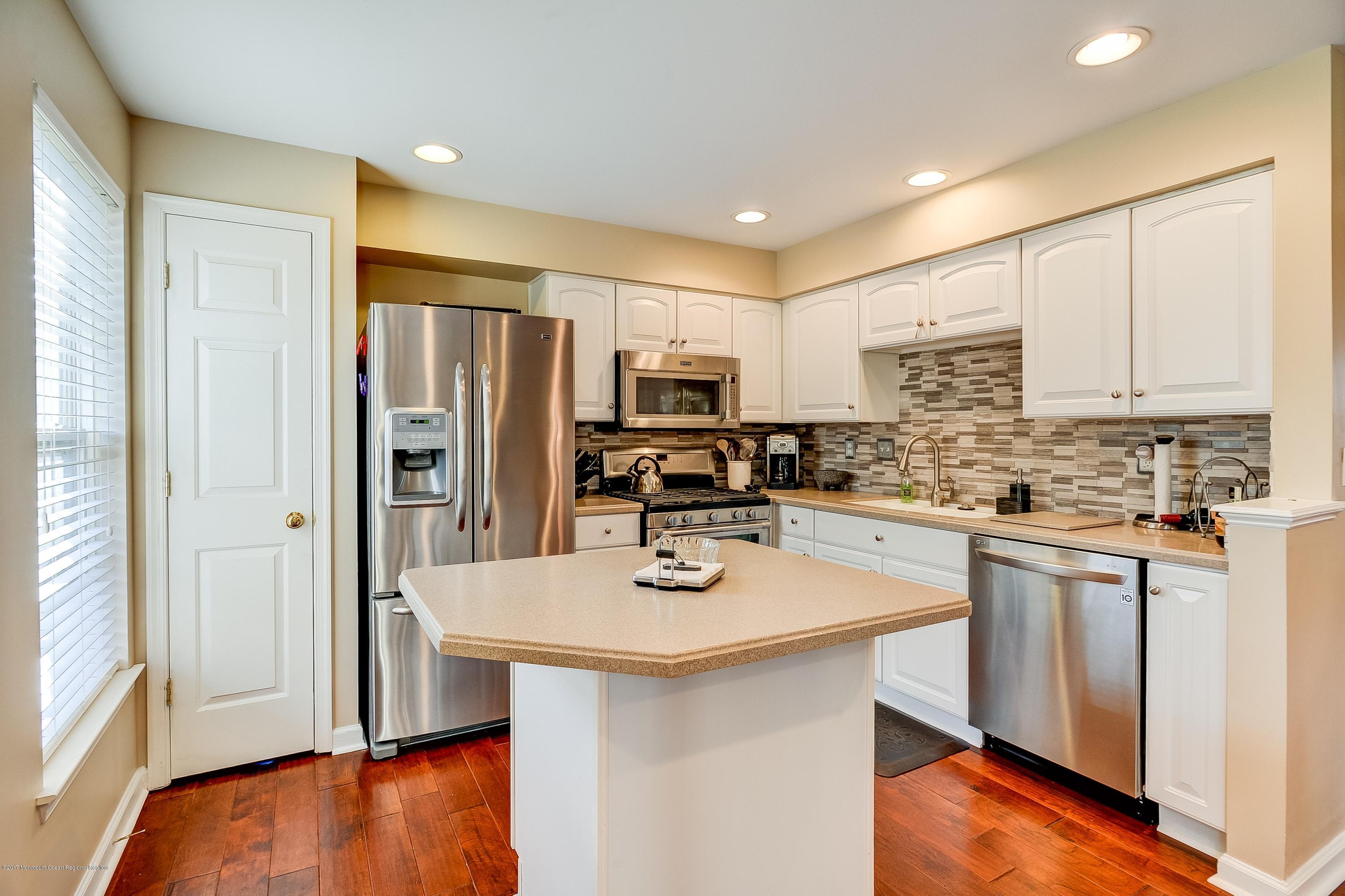 31 Saxton Road, Unit 53 Farmingdale, NJ 07727 - Photo 10 of 25 a kitchen with stainless steel appliances a refrigerator stove microwave and sink