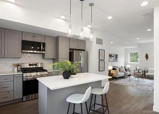 a kitchen with microwave a stove and chairs