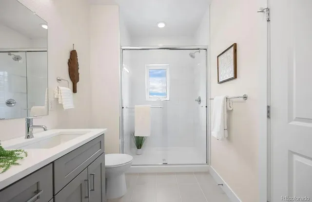 a bathroom with a granite countertop sink a toilet and shower