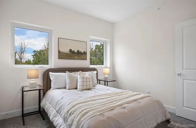 a bedroom with a bed and a painting on the wall