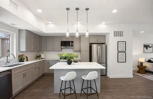 a kitchen with stainless steel appliances kitchen island granite countertop a dining table chairs and sink