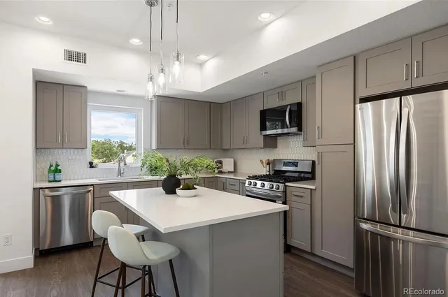 a kitchen with kitchen island a sink stainless steel appliances and cabinets