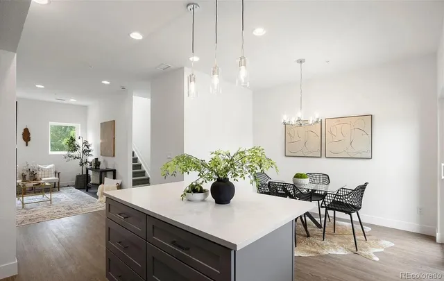 a view of a dining room and livingroom with furniture wooden floor a chandelier
