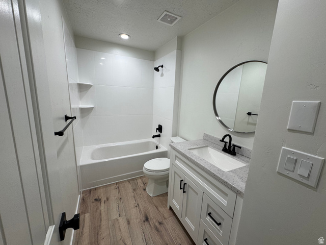 608 South 500 West, Unit 3 Provo, UT 84601 - Photo 23 of 35 Bathroom featuring a white vanity with a speckled countertop, a round mirror, and a white bathtub with black fixtures