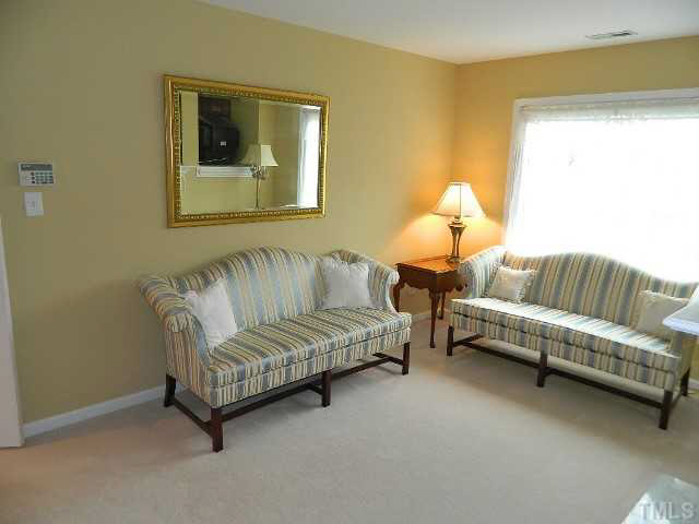 9108 Breeland Way Raleigh, NC 27613 - Photo 11 of 25 a living room with a couch and a potted plant
