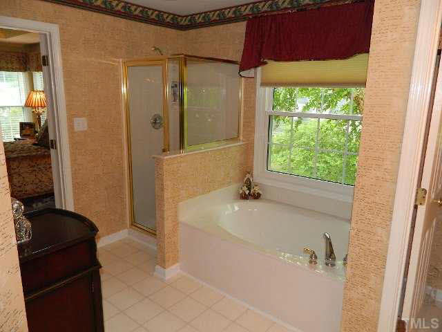 9108 Breeland Way Raleigh, NC 27613 - Photo 14 of 25 a bathroom with a bathtub and a shower