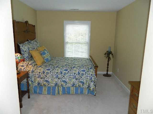 9108 Breeland Way Raleigh, NC 27613 - Photo 19 of 25 a bed sitting in a bedroom next to a window