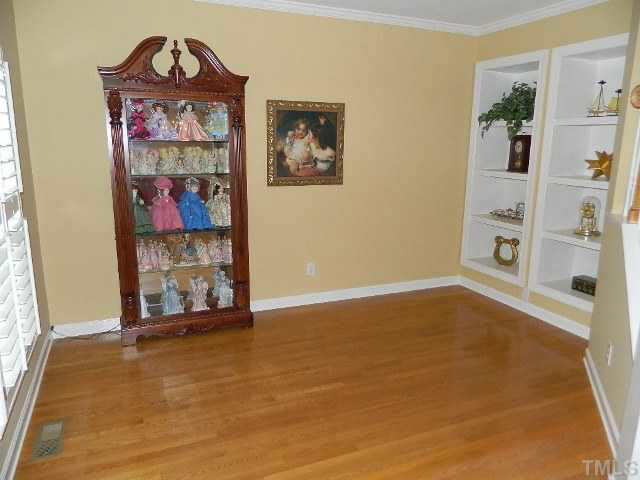 9108 Breeland Way Raleigh, NC 27613 - Photo 7 of 25 an empty room with shelves and wooden floor