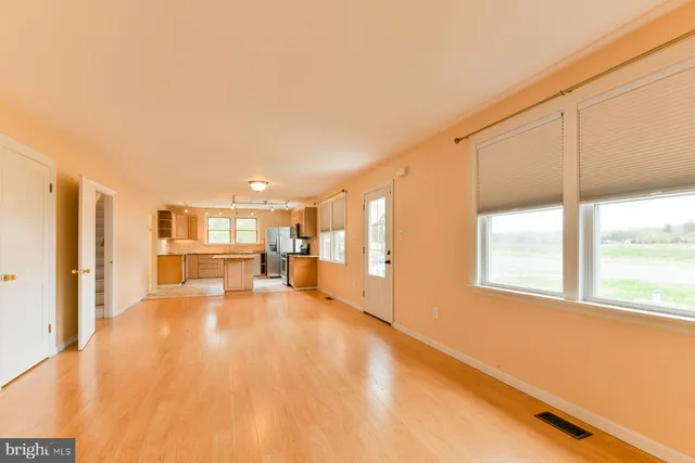 a view of a livingroom with kitchen and a window