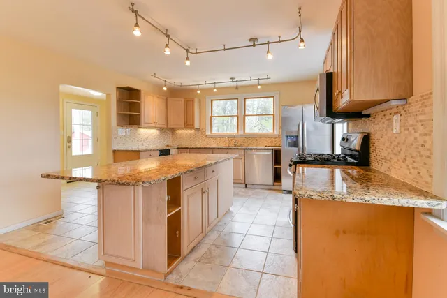 a kitchen with stainless steel appliances granite countertop a sink stove and cabinets