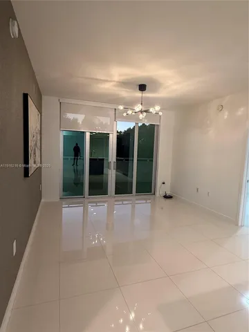a view of a big room with chandelier and windows