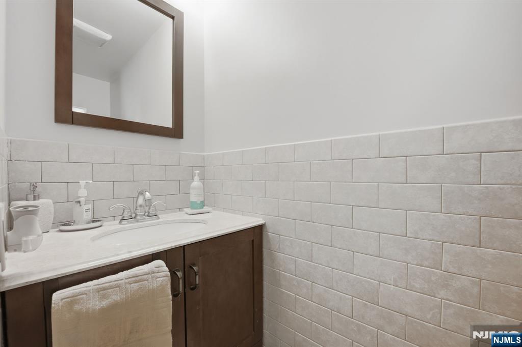 41 Woodland Road Bloomfield, NJ 07003 - Photo 3 of 27 a bathroom with a sink vanity and a mirror