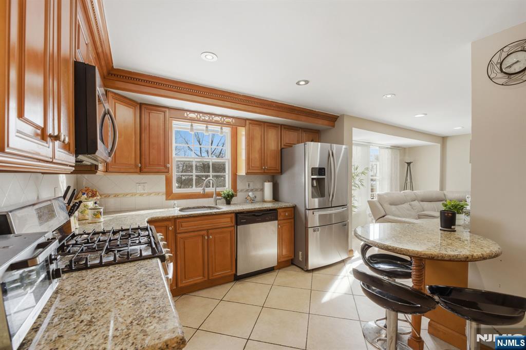 41 Woodland Road Bloomfield, NJ 07003 - Photo 7 of 27 a kitchen with a stove a sink and a refrigerator