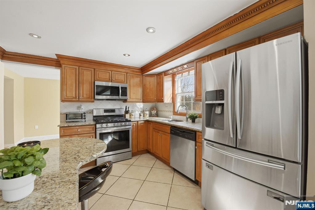 41 Woodland Road Bloomfield, NJ 07003 - Photo 8 of 27 a kitchen with stainless steel appliances granite countertop a refrigerator sink and stove