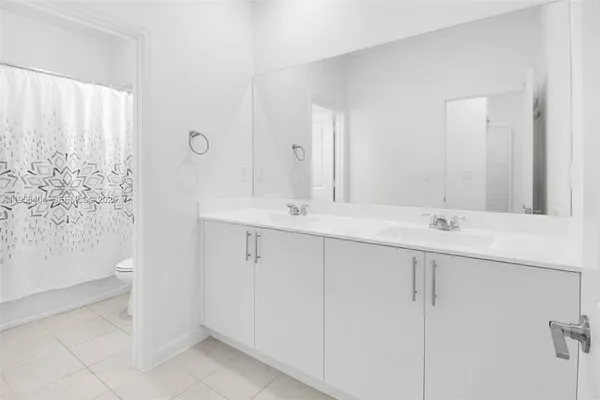 a bathroom with a double vanity sink and a mirror