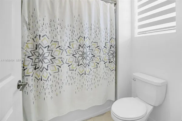 a white toilet sitting next to a shower curtain