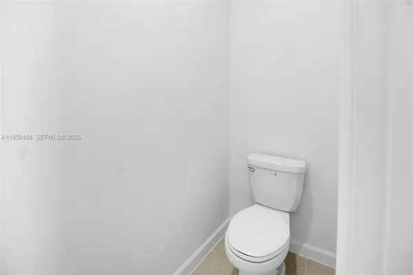 a white toilet sitting next to a white wall