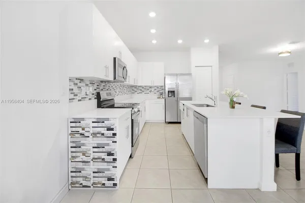 a large white kitchen with cabinets