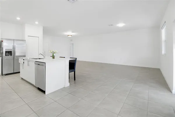 a kitchen with stainless steel appliances kitchen island sink refrigerator and cabinets