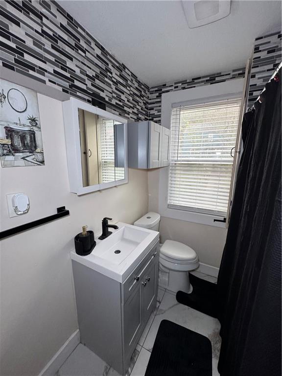 649 Singer Place Pittsburgh, PA 15221 - Photo 10 of 20 a bathroom with a sink a toilet and a window