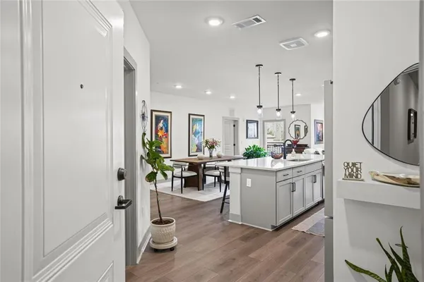 a kitchen with stainless steel appliances kitchen island wooden floors and white cabinets